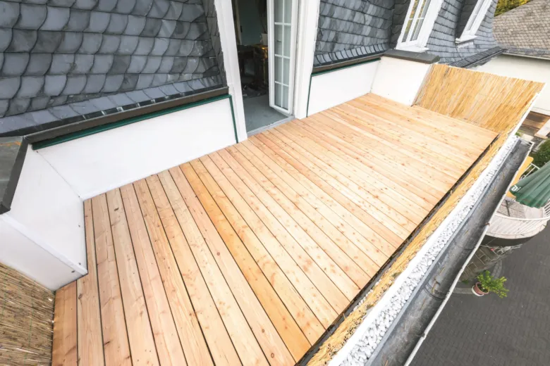 Nová dřevěná podlaha na balkónu s viditelnou izolací.