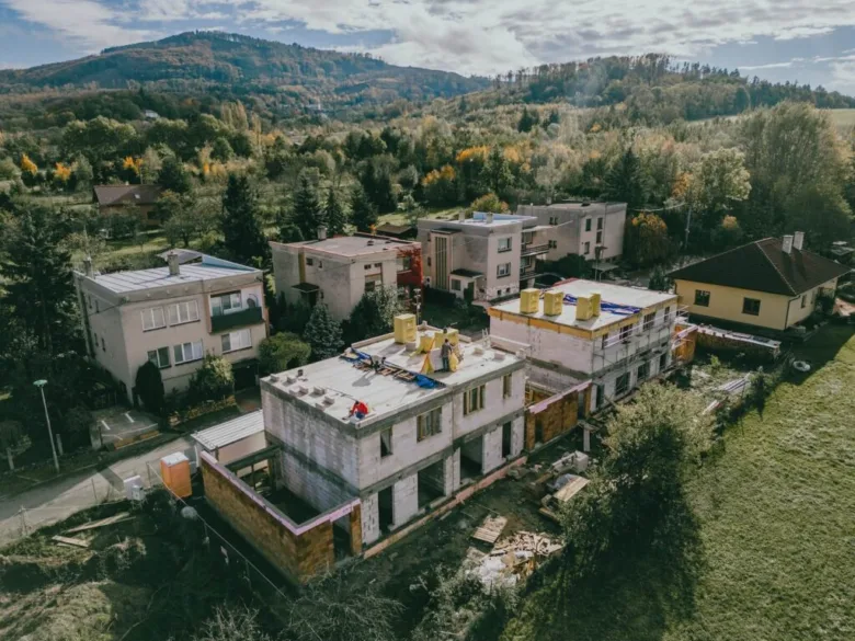Vzdušný pohled na domy ve výstavbě v přírodním prostředí.