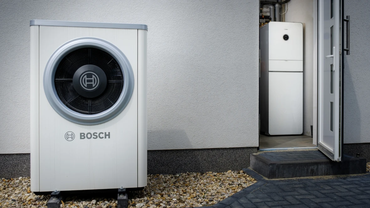 Bosch tepelné čerpadlo venku s vnitřním zařízením u dveří.