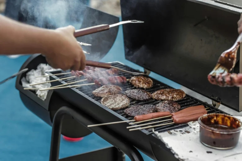 Grilování na zahradě s burgery, klobásami a špeky.