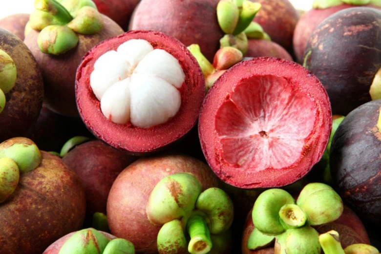 Otevřený exotický mangostan s bílým dužinou.