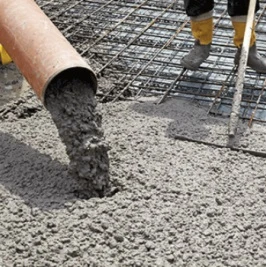 Zelený beton se nalévá na ocelovou mřížku.