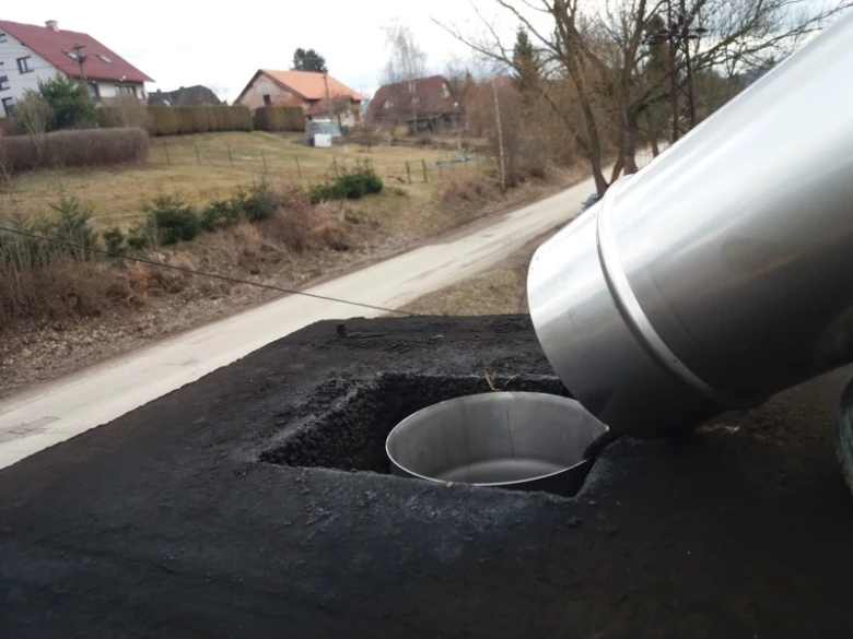 Instalace kovového komínového potrubí do střechy venkovského domu.