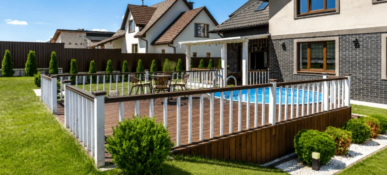 Zvýšená dřevěná terasa s bazénem a bezpečnostními zábradlím.