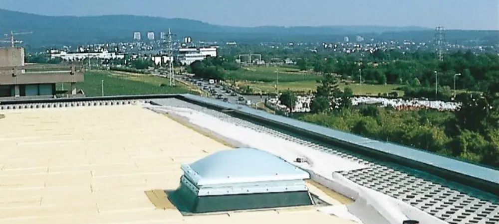 Plochá střecha bez atiky s výhledem na město.