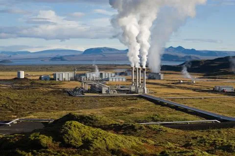 Geotermální elektrárna s výfukem páry na pozadí hor