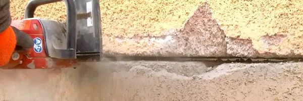 Pila řetězová seřízá základnu domu pro podrezání.