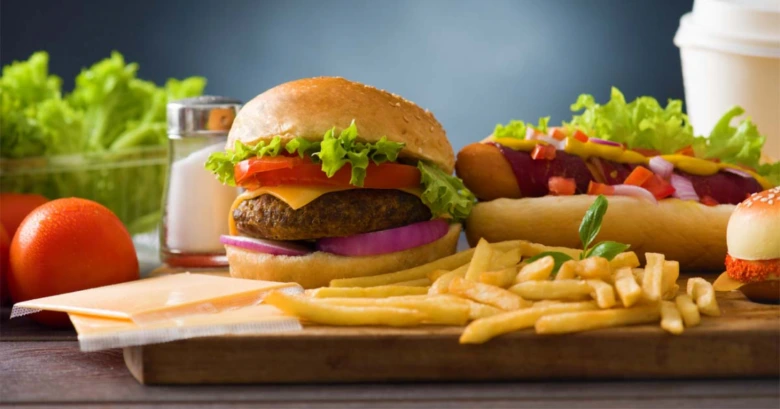 Zpracované rychlé občerstvení s burgerem, klobásou a bramborami.