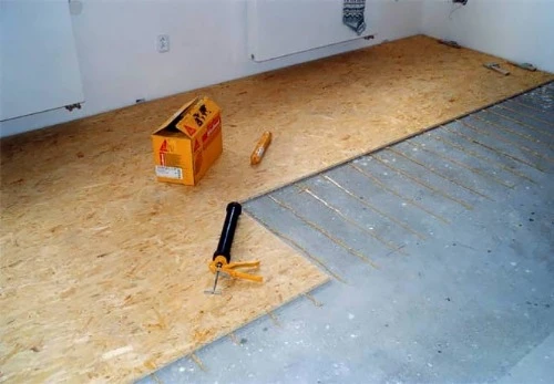 Instalace desek OSB na podlahu s použitím lepidla.