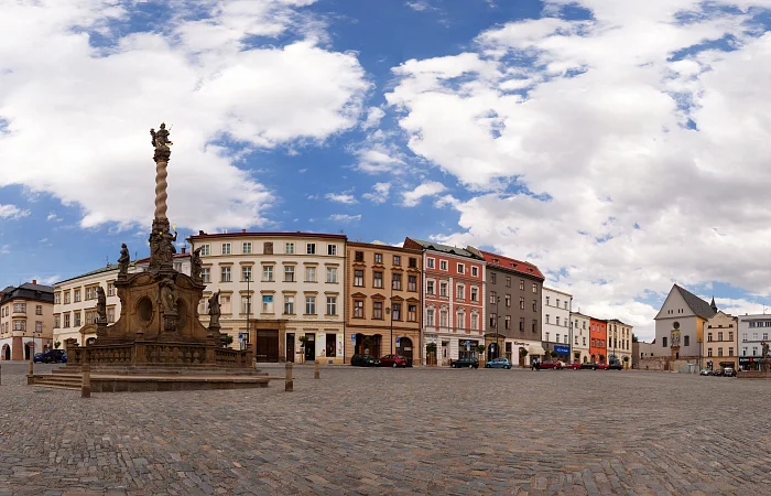 Morový sloup v Olomouci na náměstí s historickými domy.