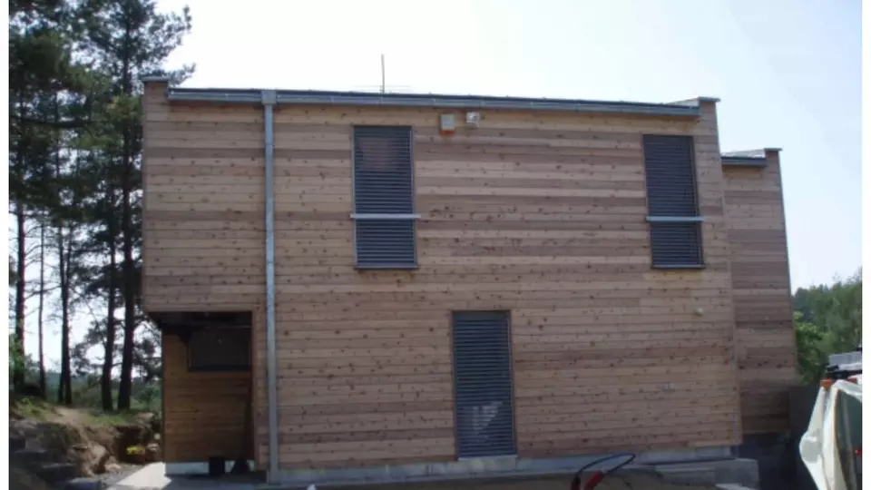 Modern dům s větranou fasádou z dřevěných prken.