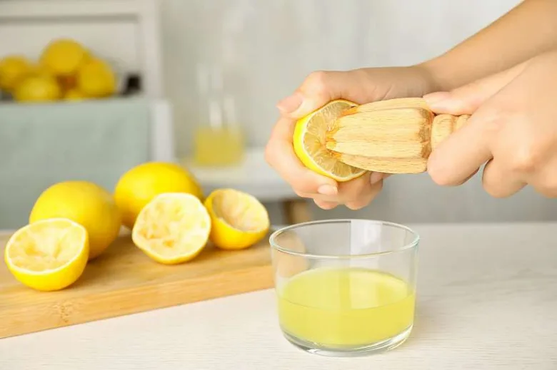 Ruční vymačkování citronu na džus v kuchyni