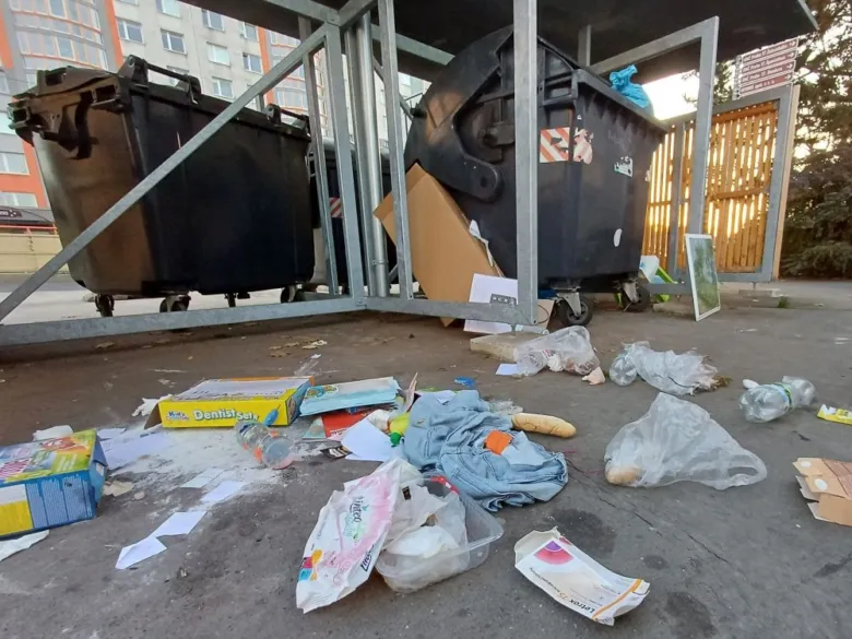 Znečištěné místo u kontejnerů s roztroušeným odpadem