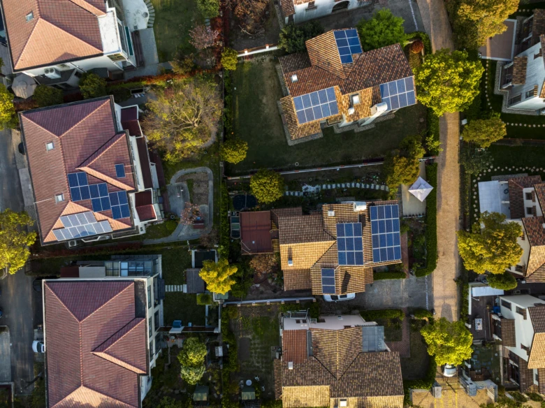Vzdušný pohled na domy s fotovoltaickými panely.