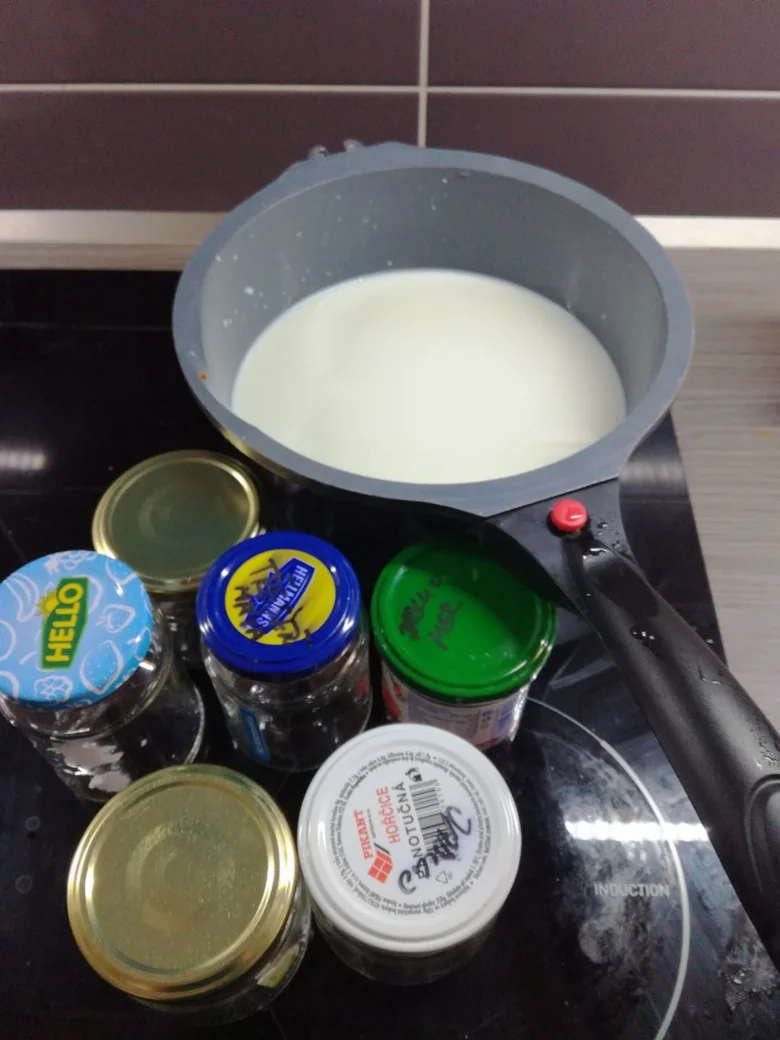 Mléko v hrnci s ingrediencemi pro domácí jogurt