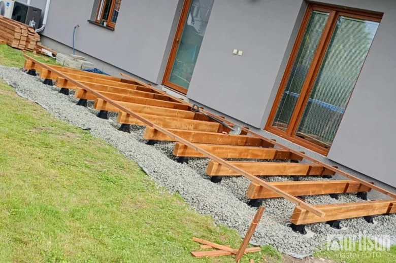 Dřevěné nosníky terasy na pilotech, instalace na štěrkové podloží