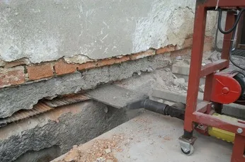 Základová příprava pro podřezání domu s vykopaným zákopem.