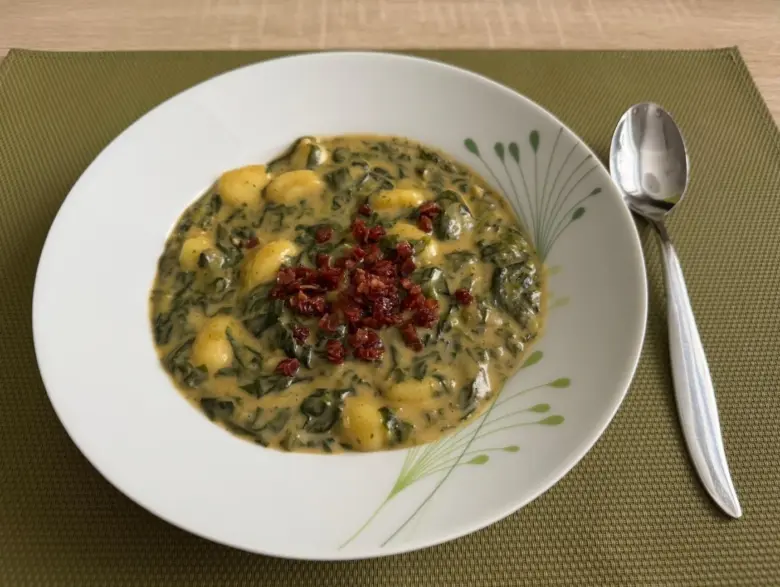 Gnocchi se špenátem, slaninou a smetanou na talíři