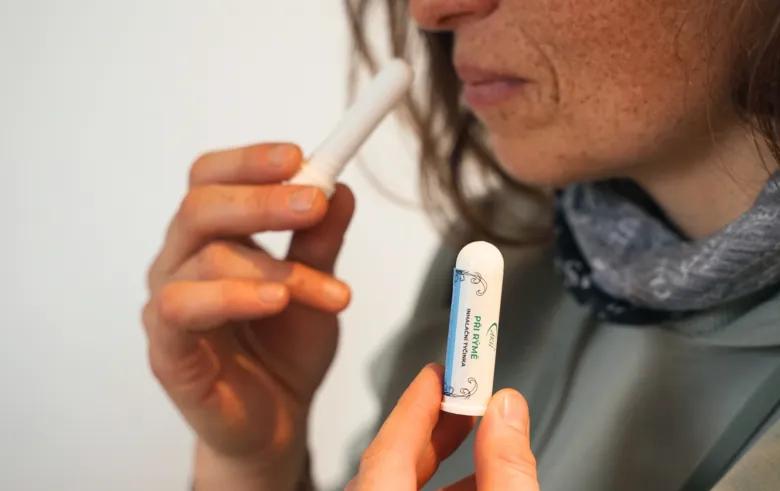 Žena drží v ruce inhalátor s extraktem z jeleního kloje.