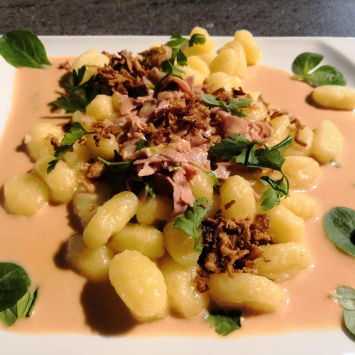 Gnocchi se špenátem, slaninou a smetanou na talíři